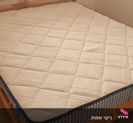 מזרן זוגי נקי ומתוח על גבי בסיס מיטה מעץ